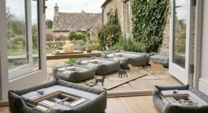 A collection of Scandi dog beds in various sizes displayed near open bifold doors leading to a green garden.