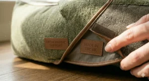 A detailed view of the premium leather branding on the traditional tweed dog bed, signifying quality and orthopaedic support.