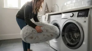 A machine-washable donut calming dog bed being placed into a washing machine after a muddy British winter walk.
