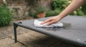 Water-resistant and easy-to-clean cover being wiped down on a durable sun-safe dog bed.