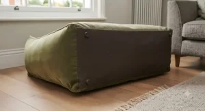 A small, grey wool designer dog bed suited for toy breeds and puppies curled up indoors.